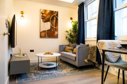 a living room with a couch and a table at Kirkgate Suites - Luxurious City Centre Apartment in Leeds