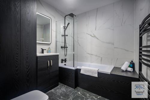 a bathroom with a tub and a sink and a shower at Isabella's Beach House Scarborough - 4 Bedroom in Scarborough