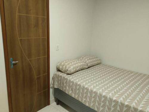 a bedroom with a bed and a wooden door at Apartamento novo e confortável in Belém