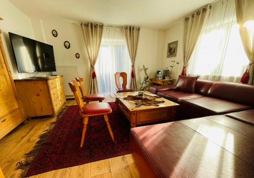 a living room with a couch and a table at Ferienwohnung Almenrausch mit 110 m2 und sonniger Terrasse in Burgberg