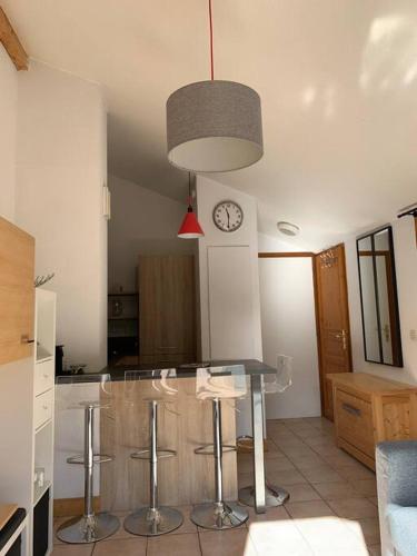 une cuisine avec une table, des chaises et une horloge dans l'établissement Appartement vue piste de ski, à Praz-sur-Arly