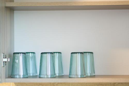 a row of silver cups sitting on a shelf at Westwood Residences in Arusha
