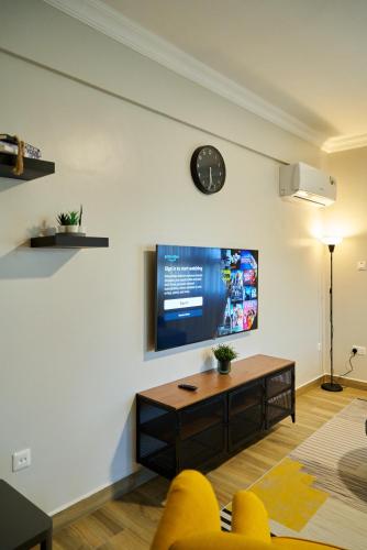 a living room with a flat screen tv on a wall at Westwood Residences in Arusha