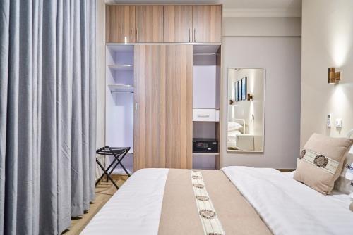 a bedroom with a large bed and a mirror at Westwood Residences in Arusha