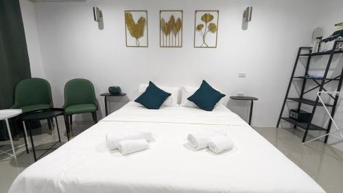 a white bed with two pillows on top of it at Chu-Cha's Rooms in Koh Samui 