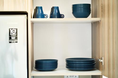 a shelf with blue bowls and plates on it at Westwood Residences in Arusha