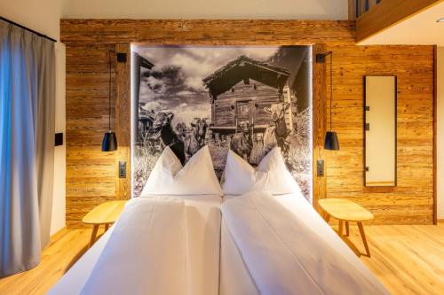 a bed in a room with a painting on the wall at Mountain Lodge in Grächen