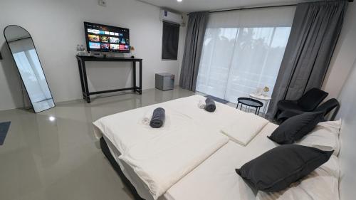 a large room with a bed and a television at Chu-Cha's Rooms in Koh Samui