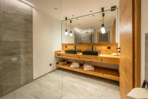 a bathroom with two sinks and a mirror at Mountain Lodge in Grächen
