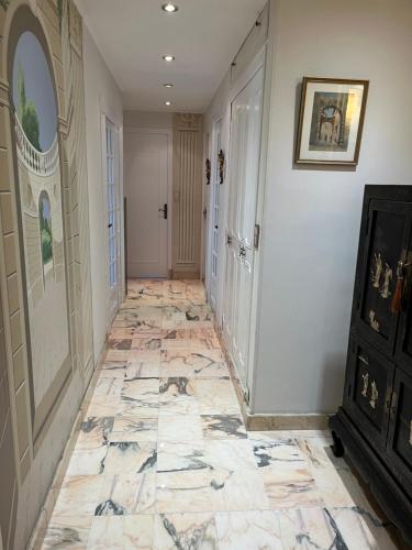 a hallway with a tiled floor in a home at Plein coeur de Monaco, à 300 mètres à pied du port de Monaco, 4 pièces dans des escaliers vue mer exceptionnelle in Monte Carlo