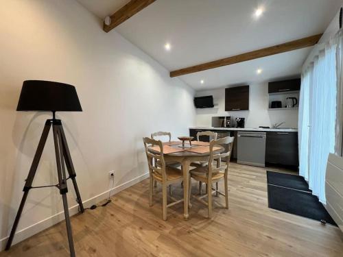 - une salle à manger avec une table, des chaises et un tripode dans l'établissement La Moretaine - 300’m gare, à Moret-sur-Loing