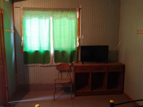 Habitación con escritorio, TV y ventana. en Nueva Era, en Viña del Mar
