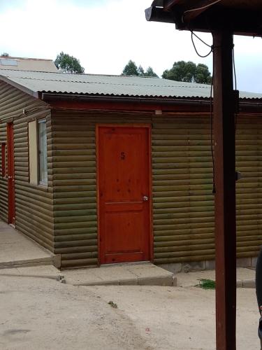 un edificio de madera con una puerta roja. en Nueva Era, en Viña del Mar