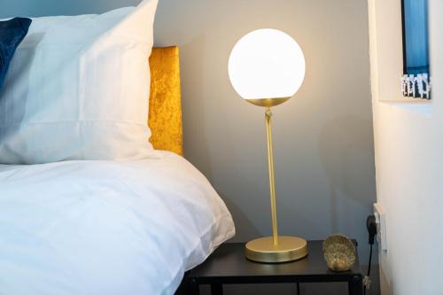 a lamp sitting on a table next to a bed at Sky Rooms Studio Apartment 7 in Birmingham