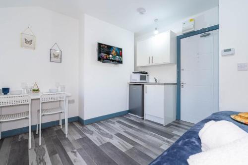 a white room with a kitchen and a bed at Sky Rooms Studio Apartment 7 in Birmingham
