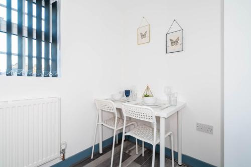 un comedor blanco con una mesa y sillas blancas en Sky Rooms Studio Apartment 7 en Birmingham