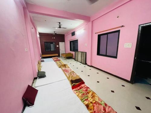 a room with pink walls and a long corridor at Hotel Aashirwad in Maheshwar
