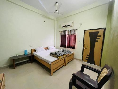 a bedroom with a bed and a chair in it at Hotel Aashirwad in Maheshwar