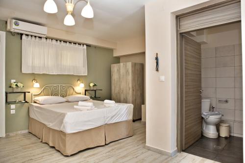 a bedroom with a bed and a toilet at Axion Esti Apartments in Skopelos Town