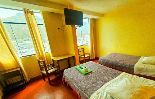 a hotel room with a bed and a tv at HOSTAL DALIA in Chivay