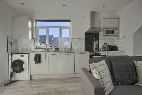 uma cozinha com máquina de lavar e secar roupa num quarto em GuestReady - Comfortable Leeds City Apartment em Kirkstall