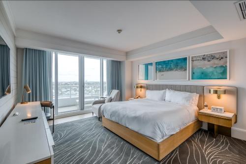 Cette chambre comprend un lit et une grande fenêtre. dans l'établissement The Residential Suites at the Ritz-Carlton, Fort Lauderdale #1510, à Fort Lauderdale