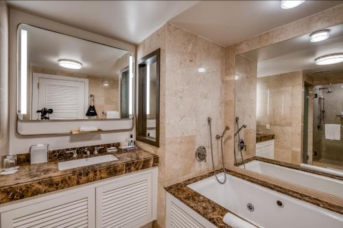 La salle de bains est pourvue d'une baignoire et d'un grand miroir. dans l'établissement The Residential Suites at the Ritz-Carlton, Fort Lauderdale #1510, à Fort Lauderdale