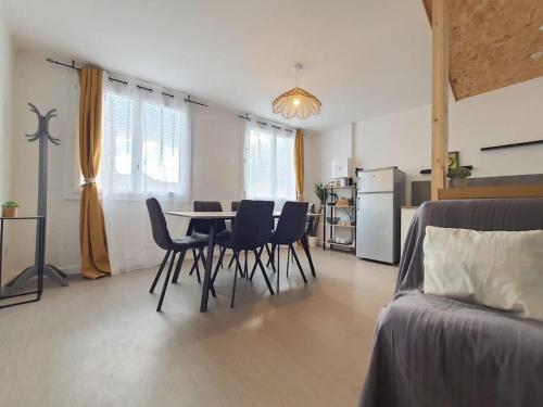 un salon avec une table et des chaises et une cuisine dans l'établissement Appart village Gruissan : le flamant-rose, à Gruissan