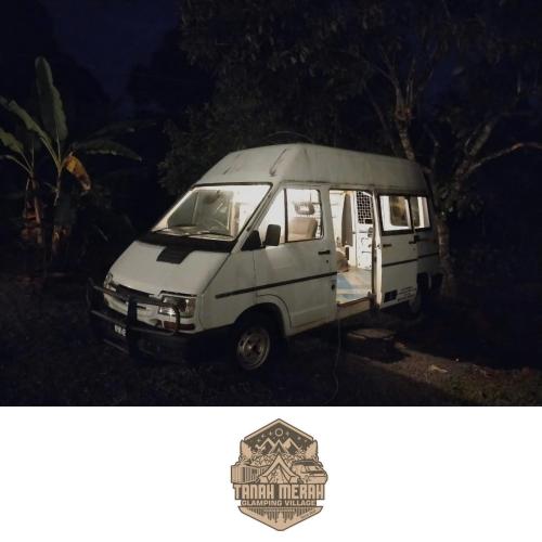 a white van is parked in a field at Tanah Merah Glamping Village (TMGV) in Kuala Kangsar