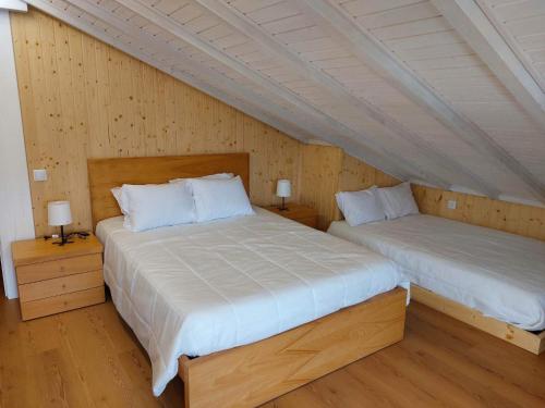 - 2 lits dans une chambre dotée de murs en bois dans l'établissement Casa Pinhão de Sousa, à Vieira do Minho