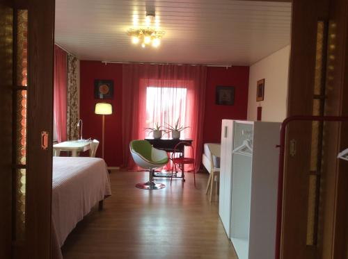 1 dormitorio con cama, escritorio y mesa en Rote Etage Pension mit Balkon, 4 km von Kitzingen nur 16 km von Würzburg! en Mainstockheim