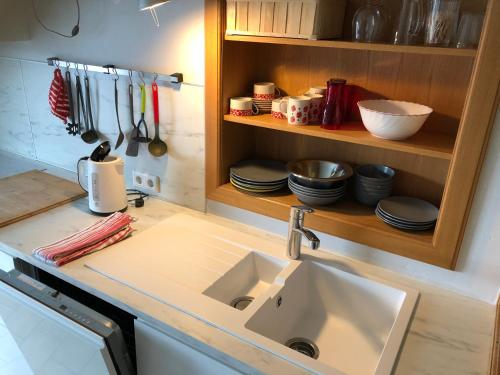 a kitchen with a sink and a shelf with utensils at Rote Etage Pension mit Balkon, 4 km von Kitzingen nur 16 km von Würzburg! in Mainstockheim