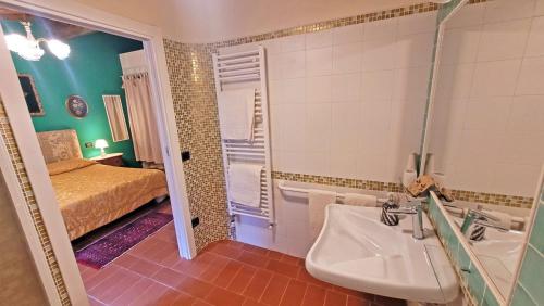 łazienka z umywalką i łóżkiem w pokoju w obiekcie Locanda Le Panche w mieście Pistoia