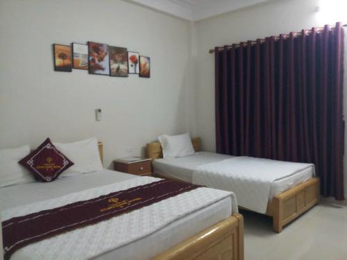 sypialnia z 2 łóżkami i oknem z zasłonami w obiekcie Motel Hằng Hiên 