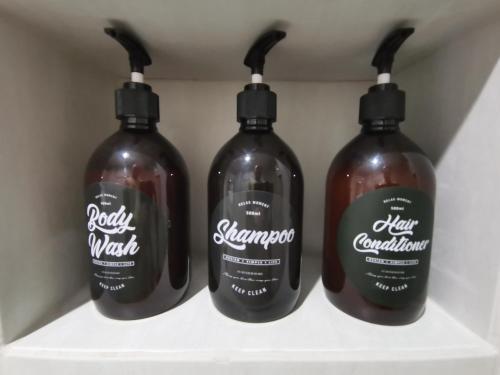 a group of four bottles of liquid sitting on a shelf at Chu-Cha's Rooms in Koh Samui 