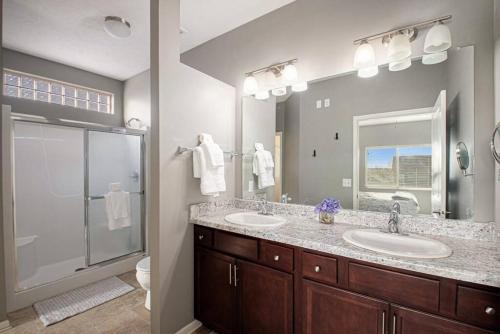 a bathroom with two sinks and a shower at Stylish Retreat Master Suite in Omaha