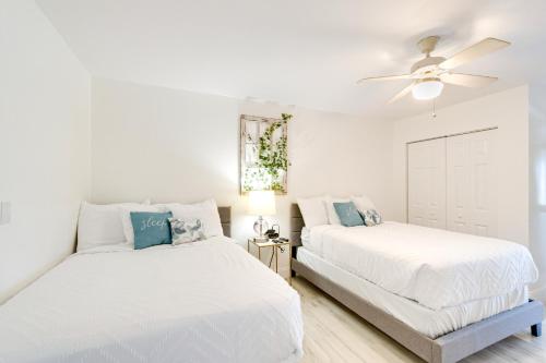 ポート・シャーロットにあるWaterfront Port Charlotte Gem with Gas Grill and Lanaiの白いベッドルーム(ベッド2台、天井ファン付)