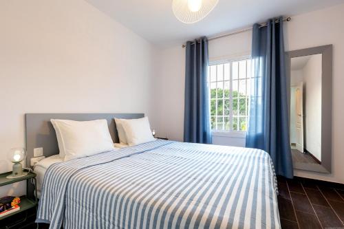 um quarto com uma cama com cortinas azuis e uma janela em Bungalow in Golf del sur em San Miguel de Abona