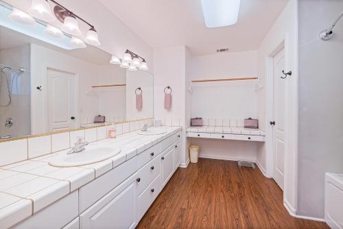 ein weißes Badezimmer mit zwei Waschbecken und einem großen Spiegel in der Unterkunft Yosemite Bass Lake Adventure Oasis in Bass Lake