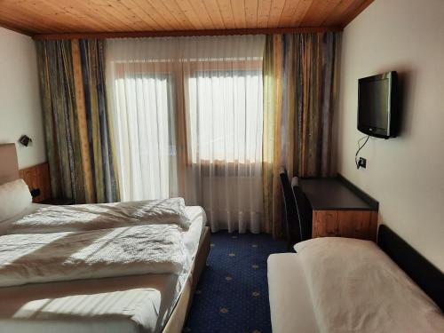 a hotel room with two beds and a television at Haus Paznaun in Kappl