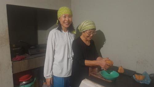 two women standing in a kitchen preparing food at Wild View Stay in Habarana