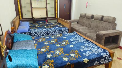 um quarto com duas camas e um sofá em KS Home Stay em Tiruchchendūr