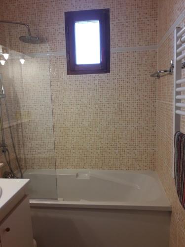 a bathroom with a bath tub and a window at LA Source Blanche in Saint-Jean