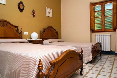 1 dormitorio con 2 camas y ventana en Casa Carrera Rural en Biscarrués