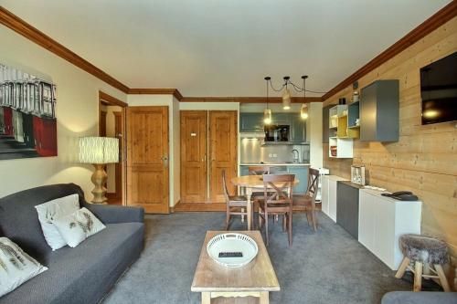 un salon avec un canapé et une table dans l'établissement ARC 1950 - Appartement 5 personnes - ski aux pieds - Sauna, Hammam, Jacuzzi, à Arc 1950