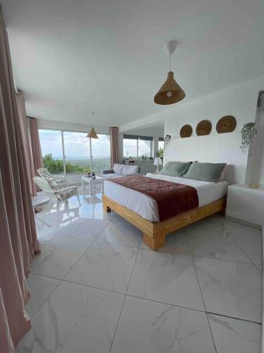 a bedroom with a bed and a living room at Apartamento panorámico vista al mar in Las Galeras