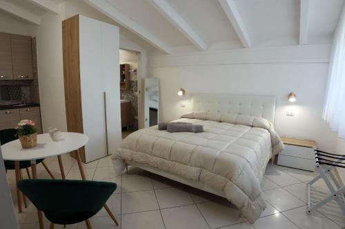 a bedroom with a bed and a table and a kitchen at La casa dei nonni in San Giuseppe Vesuviano