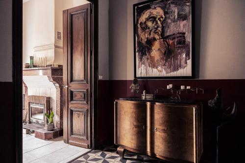 a room with a wooden cabinet and a painting on the wall at La promesse de l aude in Sallèles-dʼAude