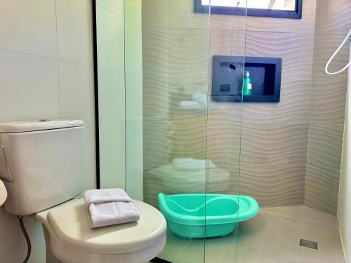 a bathroom with a toilet and a glass shower at Villa Cristalle - Campos do Jordão in Campos do Jordão