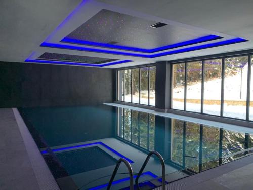 einen Pool mit blauen Lichtern in einem Zimmer in der Unterkunft Apartman 506 Aparthotel Zlatni Javor in Jahorina